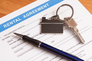 Close up of lease agreement empty document with pen and key to the house